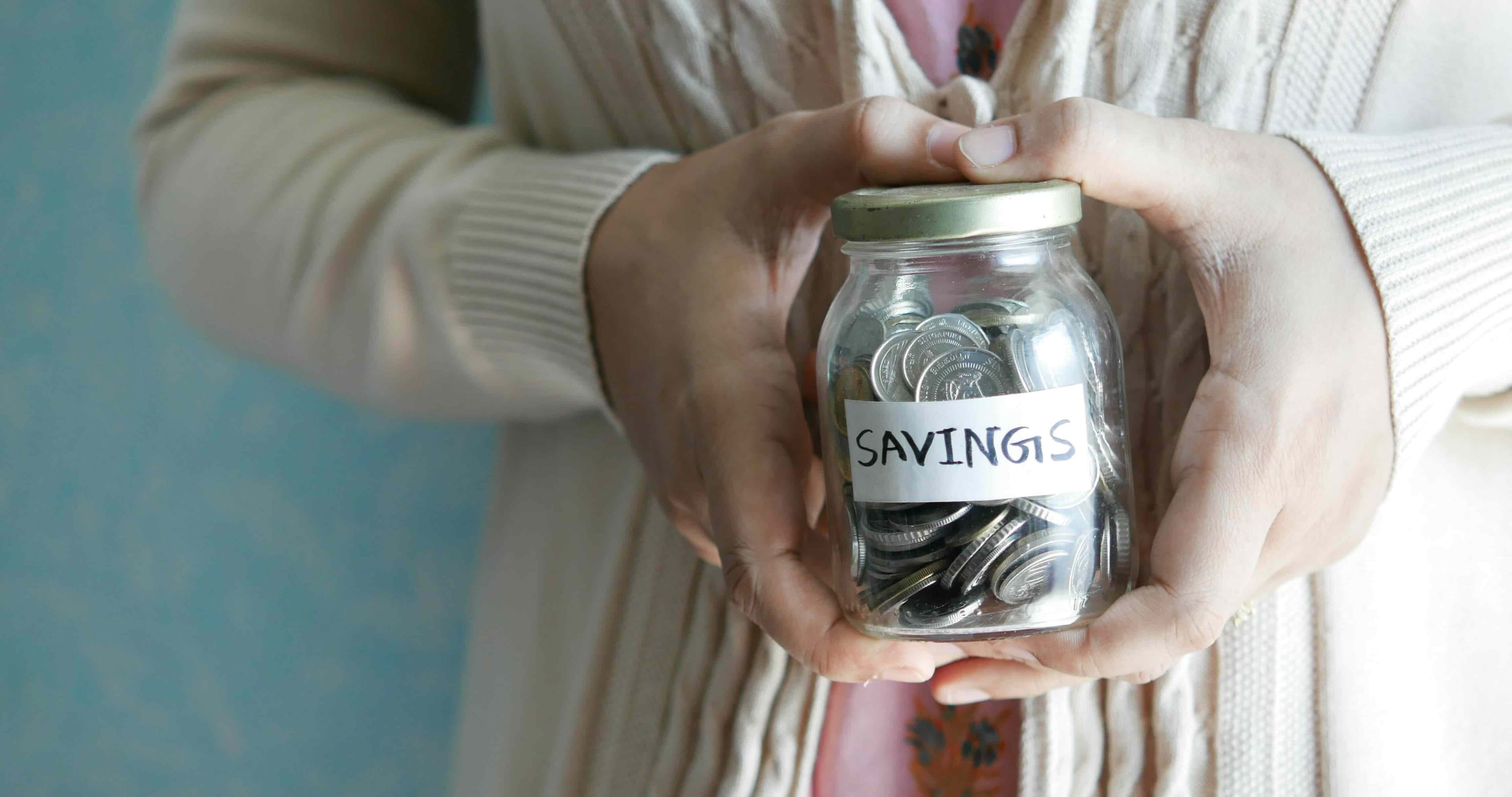 Savings jar filled with coins on a kitchen counter