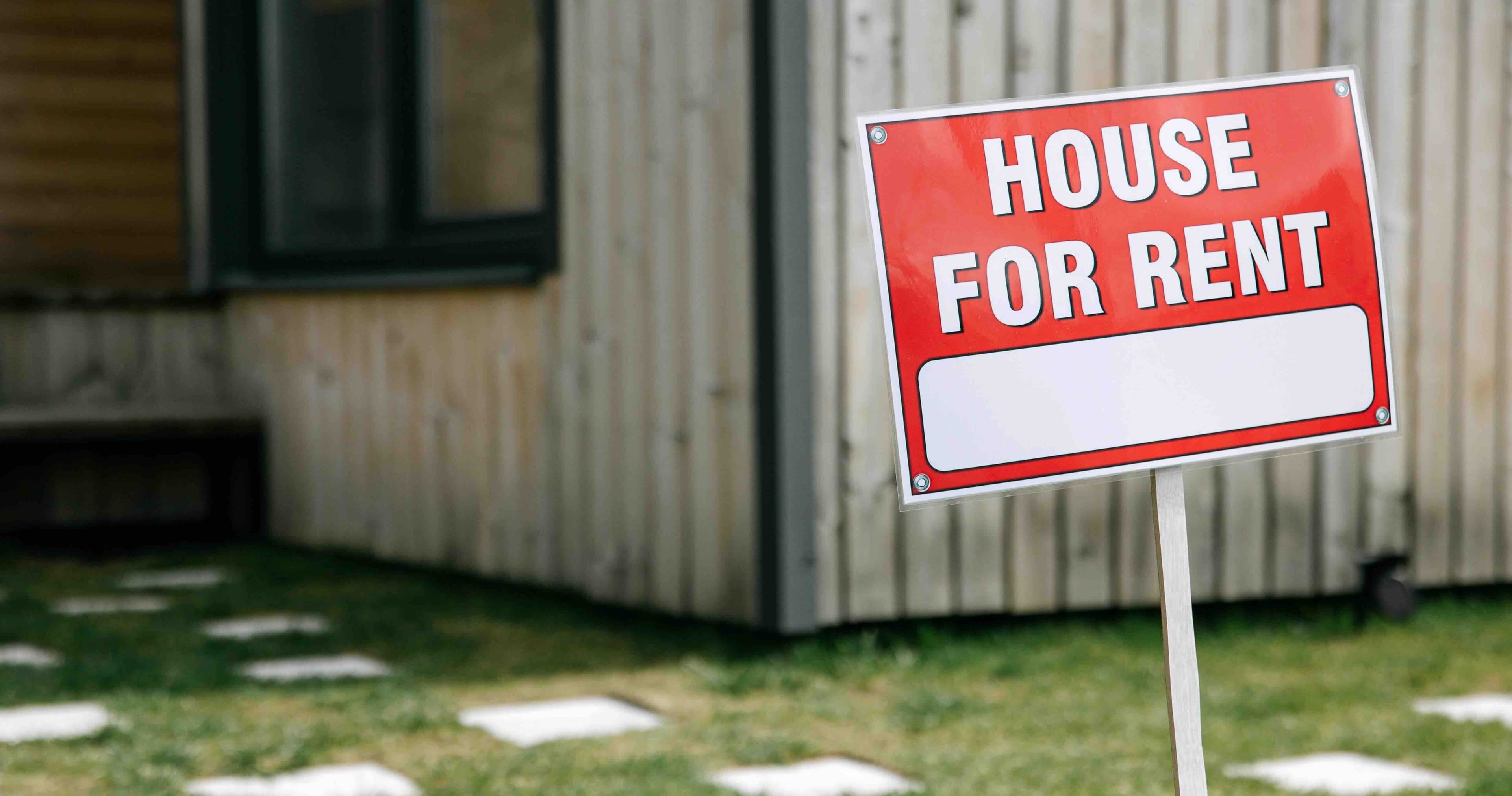 House with a for-rent sign in the front yard
