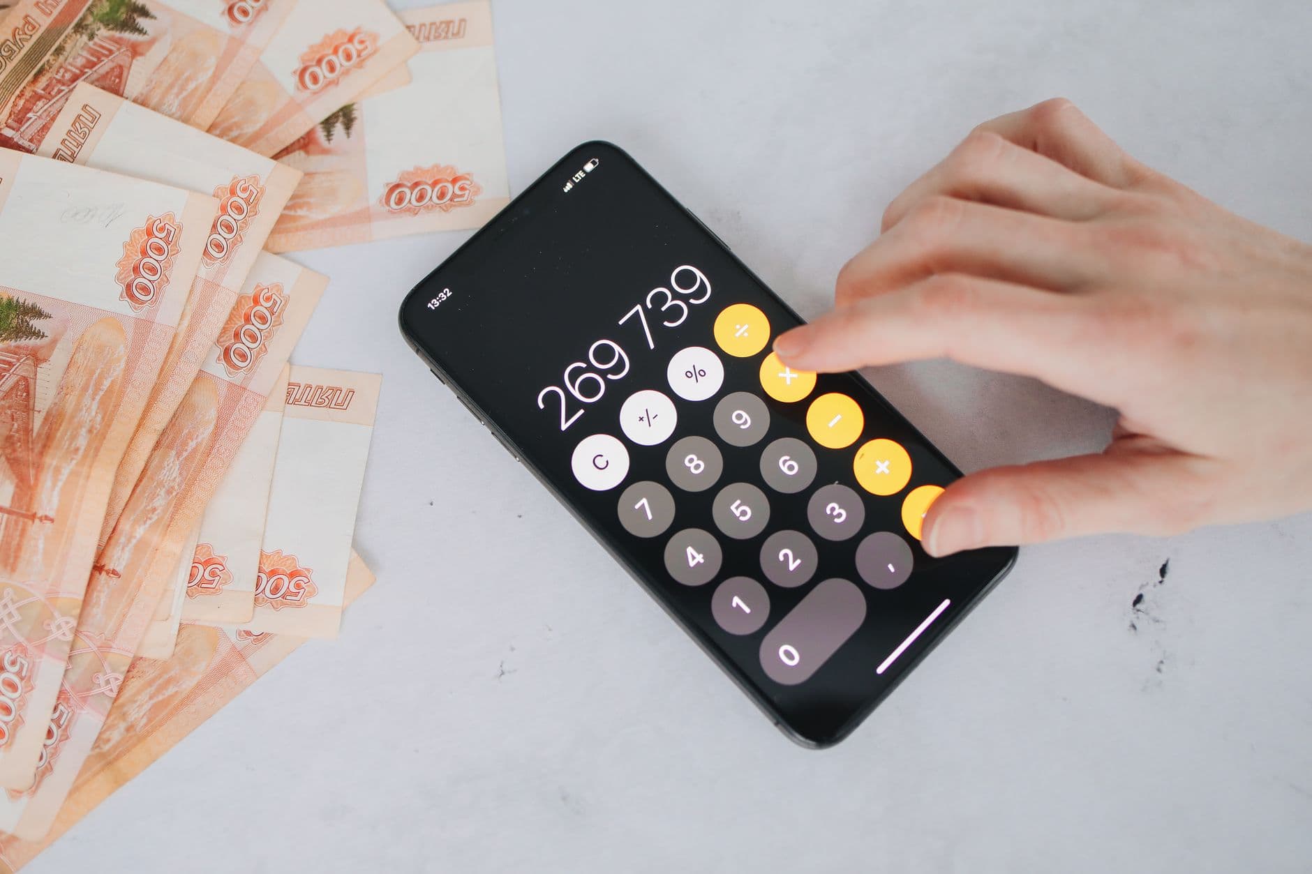 Person using a budgeting app on a smartphone to track bills and spending