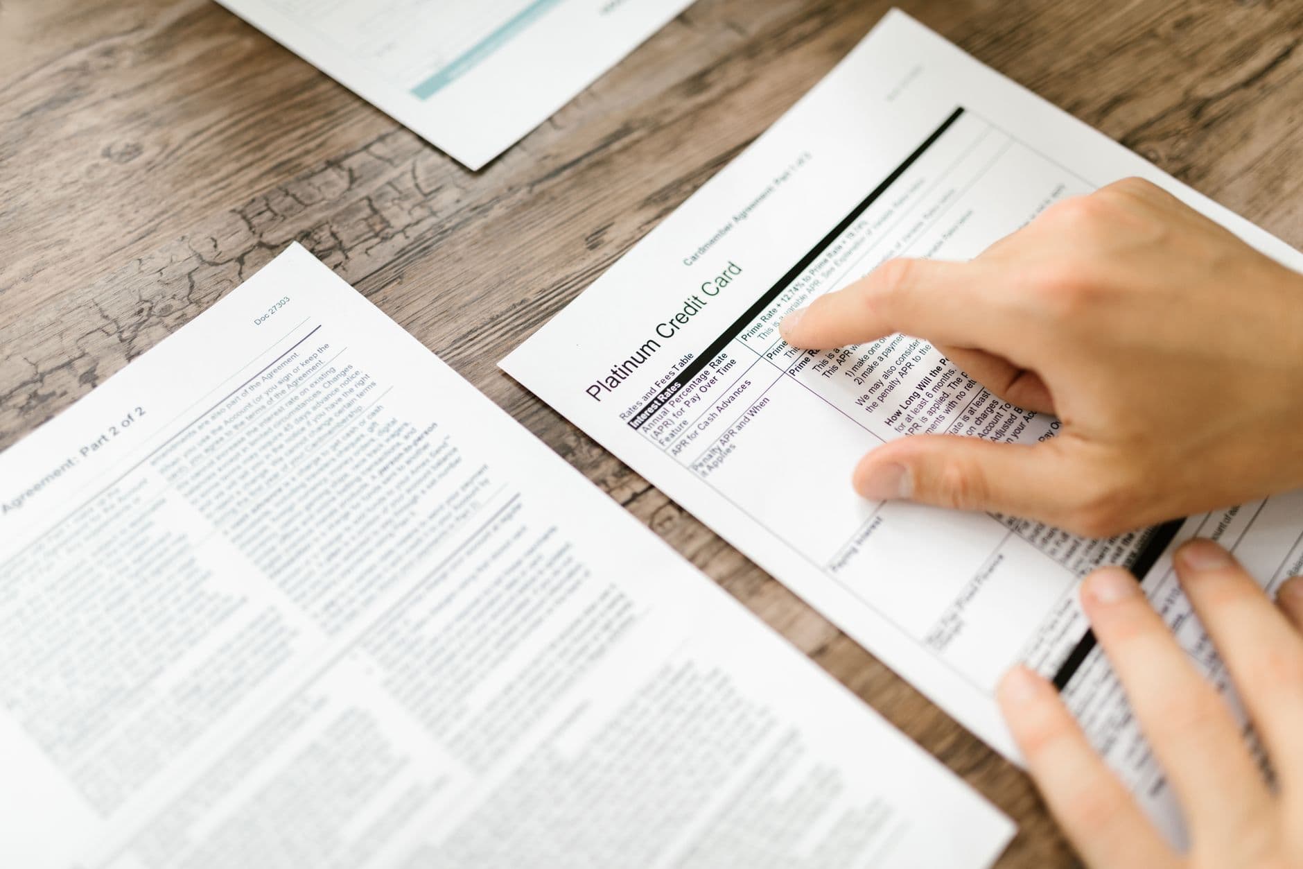 Person reviewing bank statement with overdraft charges at kitchen table