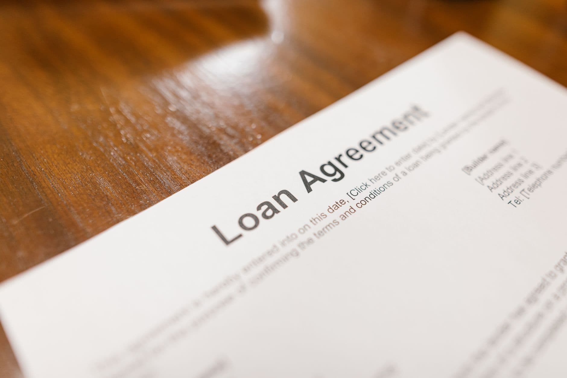 Close-up of a loan agreement document on a wooden desk