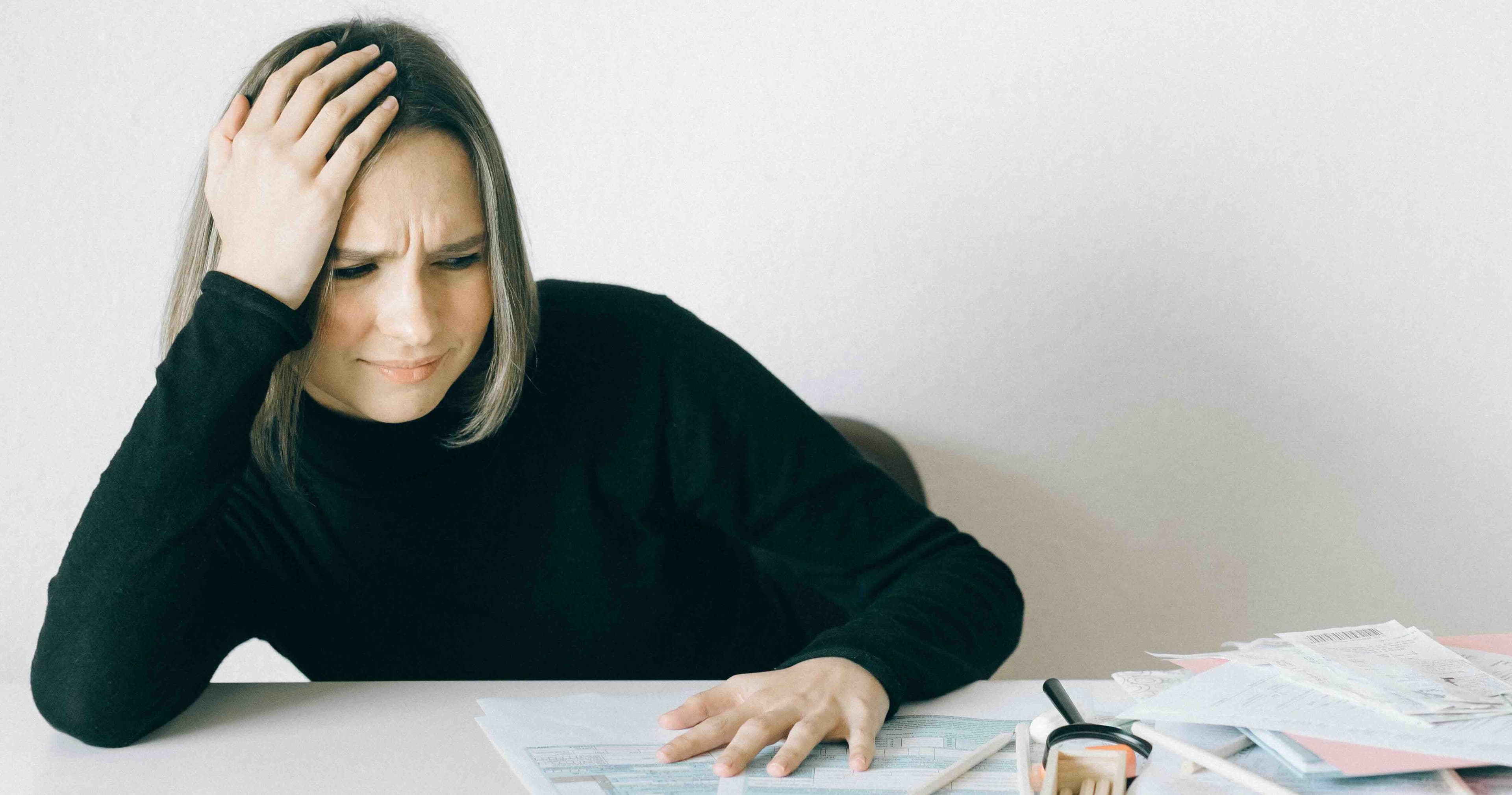 Person feeling overwhelmed while trying to start a household budget
