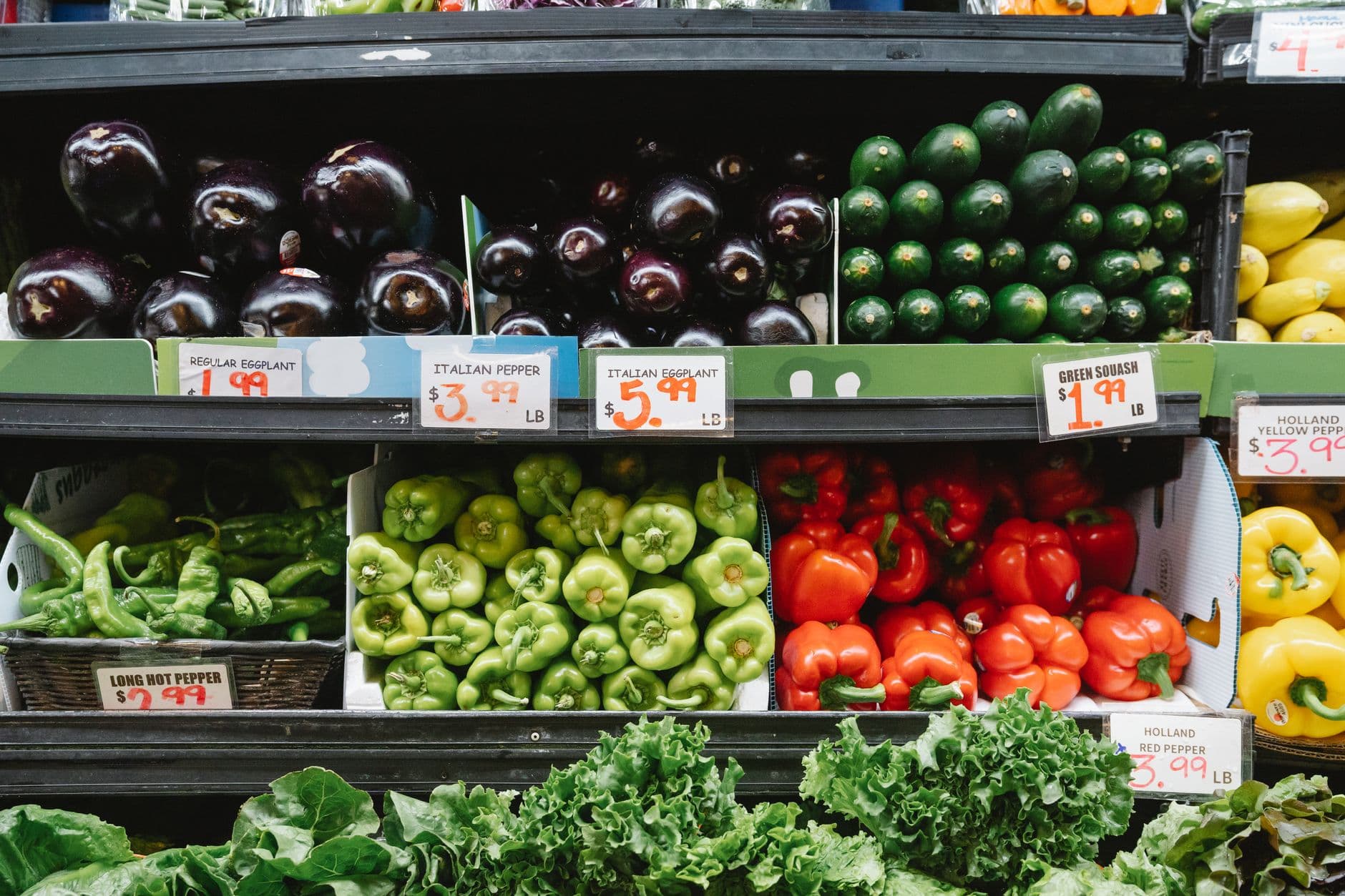 A shopper reviewing prices in a grocery store aisle in 2026