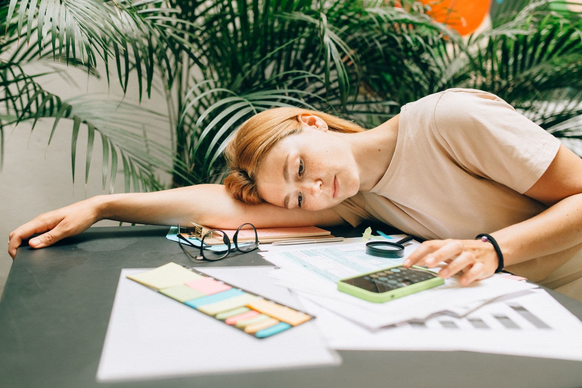 Young adult reviewing monthly bills and loan paperwork at a kitchen table