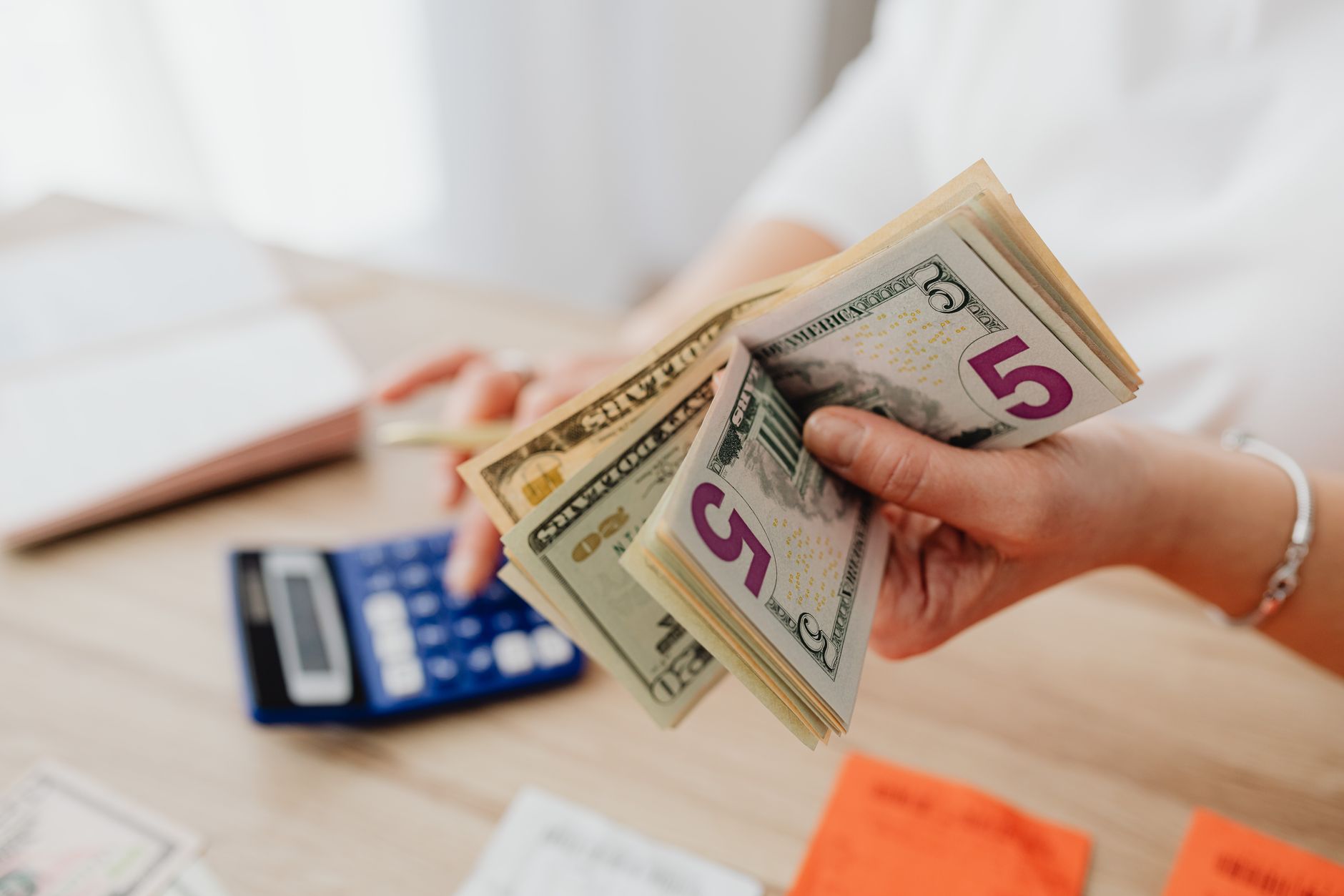 US tax documents and calculator on a desk with dollar bills